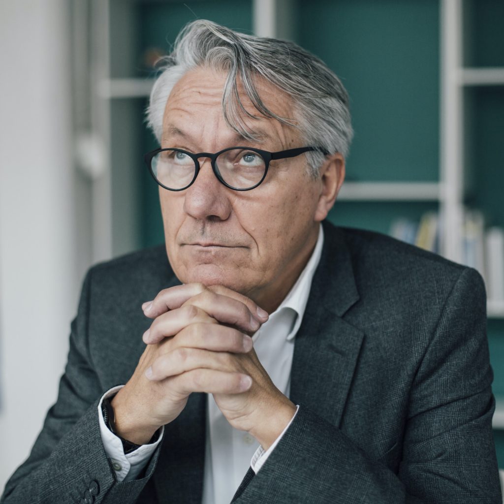 Portrait of senior businessman looking up