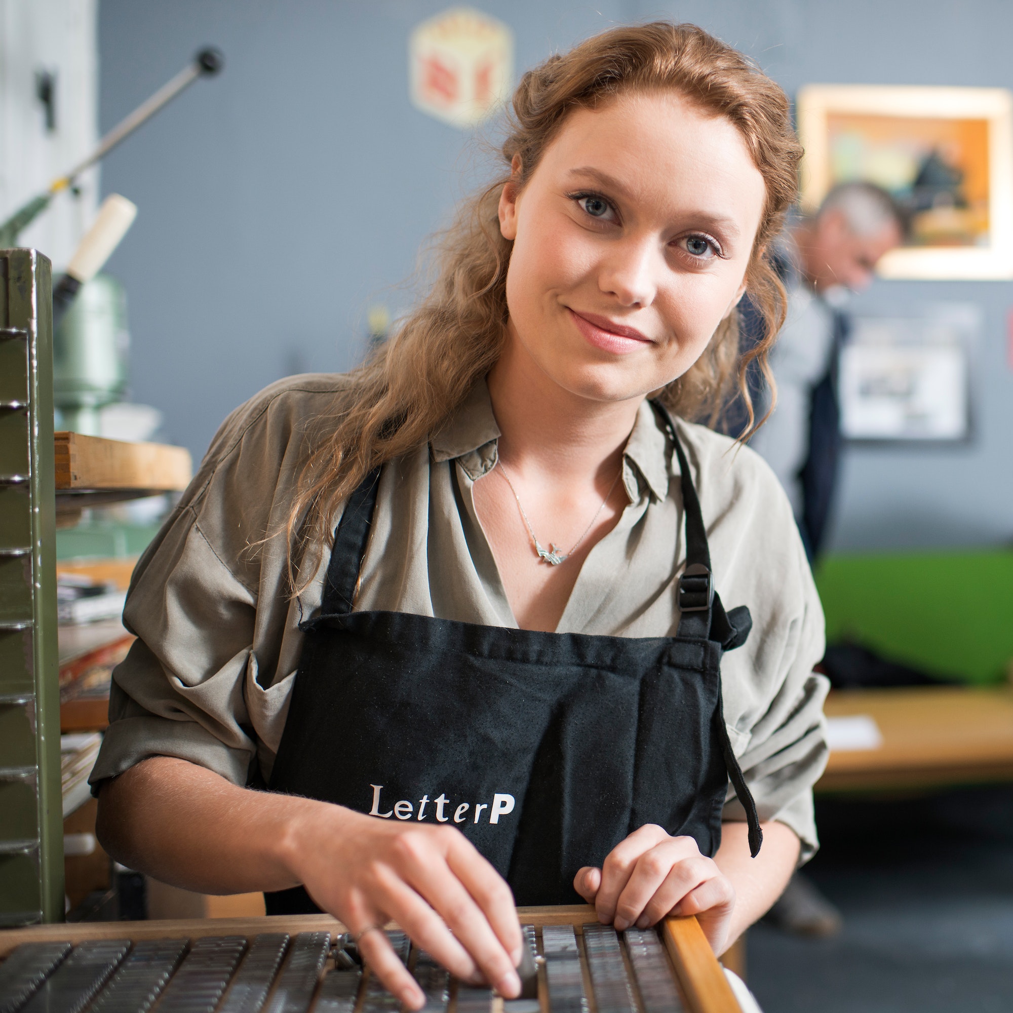 Portrait of young woman with letterpress tray in print workshop